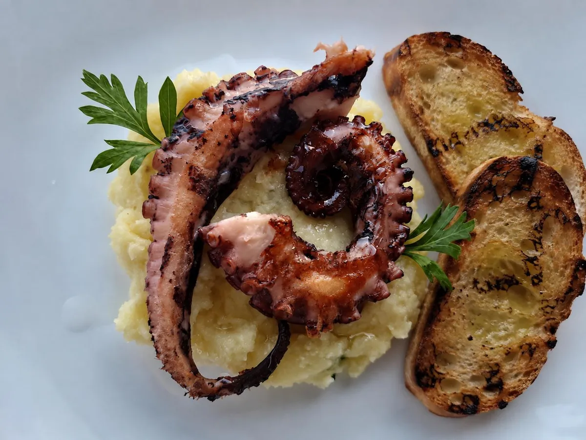 Poulpe grillé avec de pommes de terre et bruschetta